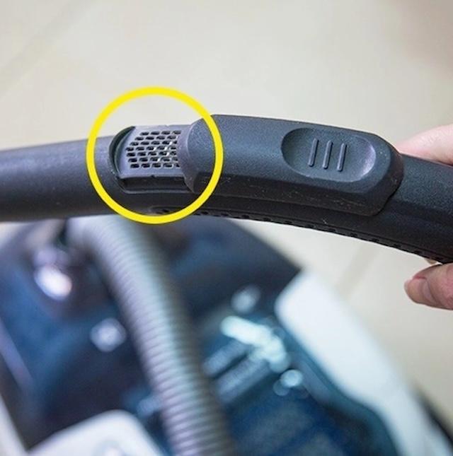 The adjustable air vent on a vacuum cleaner handle helps control suction power, useful for delicate cleaning tasks.